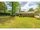 Well-maintained backyard featuring a brick home, green lawn, and manicured bushes at 6018 Ridgecrest Ave, Hanahan, SC 29410
