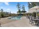 A refreshing community pool area offers seating, umbrellas, and a relaxing atmosphere surrounded by mature trees at 614 Beach Way, Summerville, SC 29486