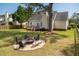 Spacious backyard featuring a fire pit, deck, a large tree, and views of surrounding greenery at 68 Oyster Point Row, Charleston, SC 29412