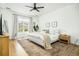Bright bedroom featuring a large window, ceiling fan, wood floors, and stylish decor at 68 Oyster Point Row, Charleston, SC 29412