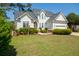 Charming two-story home with a well-manicured lawn, mature bushes, and a driveway with a garage at 68 Oyster Point Row, Charleston, SC 29412