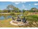 Beautiful outdoor fire pit area with seating, a pond view, and a metal fence surround at 68 Oyster Point Row, Charleston, SC 29412