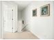 Neutral hallway with an open door, staircase and modern framed artwork hanging on a white wall at 68 Oyster Point Row, Charleston, SC 29412