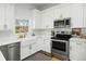 Charming kitchen featuring white cabinets, stainless steel appliances, and a farmhouse sink at 68 Oyster Point Row, Charleston, SC 29412