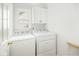 Bright laundry room with a window, upper cabinet, and modern appliances at 68 Oyster Point Row, Charleston, SC 29412
