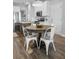 A dining area featuring a round wooden table, four metal chairs, and wood floors at 7483 Hawks Cir, Hanahan, SC 29410