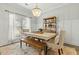 Comfortable dining room with a large window, modern table, bench seating, chandelier, and wood floors at 7483 Hawks Cir, Hanahan, SC 29410