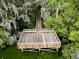Aerial view of a wooden dock with benches surrounded by trees and swampy water, creating a tranquil retreat at 7483 Hawks Cir, Hanahan, SC 29410