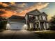 Inviting two-story home with a two-car garage and covered front entry, beautifully illuminated at twilight at 7483 Hawks Cir, Hanahan, SC 29410