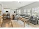 Open-concept living room with sectional seating, kitchen bar, and lots of windows at 7483 Hawks Cir, Hanahan, SC 29410