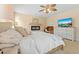 A main bedroom featuring a bed with a white comforter, ceiling fan, and a television at 7483 Hawks Cir, Hanahan, SC 29410