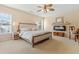 A main bedroom featuring a bed with a white comforter, ceiling fan, and fireplace at 7483 Hawks Cir, Hanahan, SC 29410