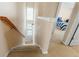 A carpeted staircase with white railings and natural light coming from a window at 7483 Hawks Cir, Hanahan, SC 29410