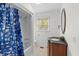 Cozy bathroom featuring a tub with shower, wood vanity, and exterior view at 753 Lake Frances Dr, Charleston, SC 29412