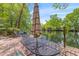 Outdoor dining set sits on waterside deck overlooking the river and trees at 753 Lake Frances Dr, Charleston, SC 29412