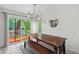 Bright dining room with a wooden table and bench, modern lighting, and access to an outdoor deck at 753 Lake Frances Dr, Charleston, SC 29412