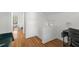 Bright hallway with hardwood floors leading to a bedroom with white bedding at 753 Lake Frances Dr, Charleston, SC 29412