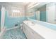 Bathroom with blue tile, floral wallpaper, a large mirror, and a window with natural light at 783 Dills Bluff Rd, Charleston, SC 29412