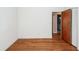 A minimalist bedroom featuring hardwood floors, white walls, and view to a bathroom at 783 Dills Bluff Rd, Charleston, SC 29412