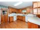 Traditional kitchen featuring wood cabinets, white appliances, and hardwood floors with a view of the backyard at 783 Dills Bluff Rd, Charleston, SC 29412