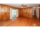 A naturally lit room with hardwood floors, wood paneling, and sliding glass doors leading to an outdoor patio at 783 Dills Bluff Rd, Charleston, SC 29412