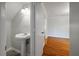 Cozy half-bath next to open doorway with hardwood floors leading to other rooms of the house at 8 Poulnot Ln, Charleston, SC 29401