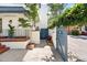 Exterior view with a white facade, blue gate, brick planter, and black railings leading to the entrance at 8 Poulnot Ln, Charleston, SC 29401