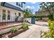 Charming front porch with brick accents, black railing, and a blue gate with climbing foliage at 8 Poulnot Ln, Charleston, SC 29401