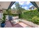 Inviting front porch with black railings, brick accents, and views of the street and lush greenery at 8 Poulnot Ln, Charleston, SC 29401