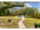 Backyard featuring a swimming pool, lush lawn, walkway, lounge chairs, and shade trees at 803 S Main St, Summerville, SC 29483