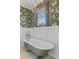 Elegant bathroom featuring a standalone tub, stylish wallpaper, and a charming chandelier at 803 S Main St, Summerville, SC 29483