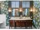 Stylish bathroom with a double sink vanity, floral wallpaper, and modern lighting at 803 S Main St, Summerville, SC 29483