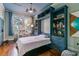 Murphy bed in a bedroom featuring custom blue cabinetry with built-in shelving and hardwood floors at 803 S Main St, Summerville, SC 29483
