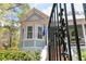 Charming light blue home with decorative metal entry gate, manicured greenery and brick stairs up to porch at 803 S Main St, Summerville, SC 29483