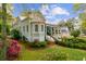 Charming light blue two-story home with a landscaped yard and mature trees along the perimeter of the property at 803 S Main St, Summerville, SC 29483