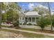 Charming light blue two-story home with a landscaped yard and a quaint white picket fence along a green lawn at 803 S Main St, Summerville, SC 29483
