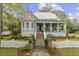 Charming light blue two-story home with a landscaped yard, brick gate posts, and a quaint white picket fence at 803 S Main St, Summerville, SC 29483