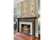 Living room fireplace with detailed wood mantel, decorative panels and tiled hearth with fire burning at 803 S Main St, Summerville, SC 29483