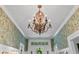 Elegant foyer with a decorative chandelier, detailed trim, and stylish floral wallpaper at 803 S Main St, Summerville, SC 29483