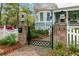 Elegant wrought iron gate with brick pillars, complementing the home's charming exterior at 803 S Main St, Summerville, SC 29483
