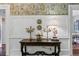 Hallway with dark wood table, lamps, flower arrangement, and decorative plates on the wall at 803 S Main St, Summerville, SC 29483