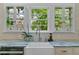 Farmhouse sink with marble countertop and view to trees in the background at 803 S Main St, Summerville, SC 29483