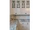 Elegant kitchen featuring marble countertops, custom cabinets, and decorative glass-front upper cabinets at 803 S Main St, Summerville, SC 29483
