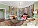 Inviting living room with a grand piano, chandelier, and comfortable seating area near the bay window at 803 S Main St, Summerville, SC 29483