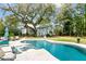 Inviting pool with in-pool loungers and a lush backyard view, creating a perfect outdoor oasis at 803 S Main St, Summerville, SC 29483