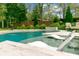 Relaxing pool area featuring in-pool loungers, a serene setting, and manicured landscaping at 803 S Main St, Summerville, SC 29483
