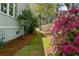 Beautifully landscaped yard with a stone path, lush greenery, and vibrant pink flowers, adding natural charm at 803 S Main St, Summerville, SC 29483