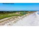 Aerial view of a lush green golf course on the ocean with a sandy beach at 83 Blue Heron Pond Rd, Kiawah Island, SC 29455