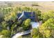 Aerial view of a wooded estate featuring a charming home and a marsh in the background at 83 Blue Heron Pond Rd, Kiawah Island, SC 29455