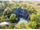 Aerial view of a wooded estate featuring a charming home and a marsh in the background at 83 Blue Heron Pond Rd, Kiawah Island, SC 29455